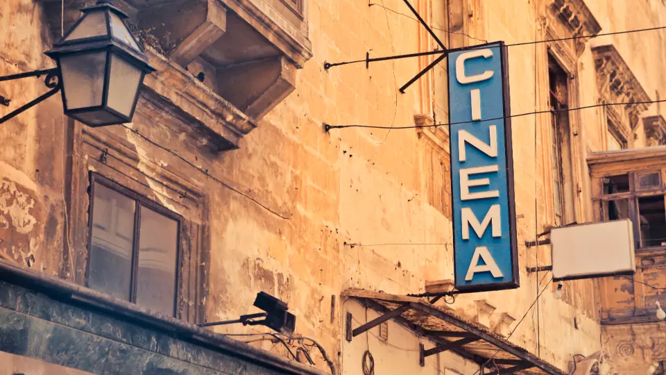 Eski bir binanın cephesinde dikey sinema tabelası