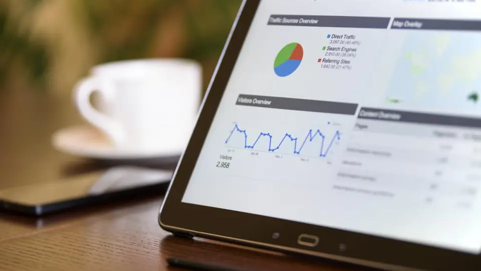 Kahve fincanının yanında grafik ve tablolar gösteren tablet